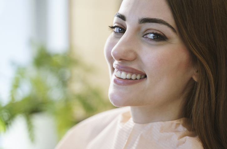 smiling woman after receding gums treatment