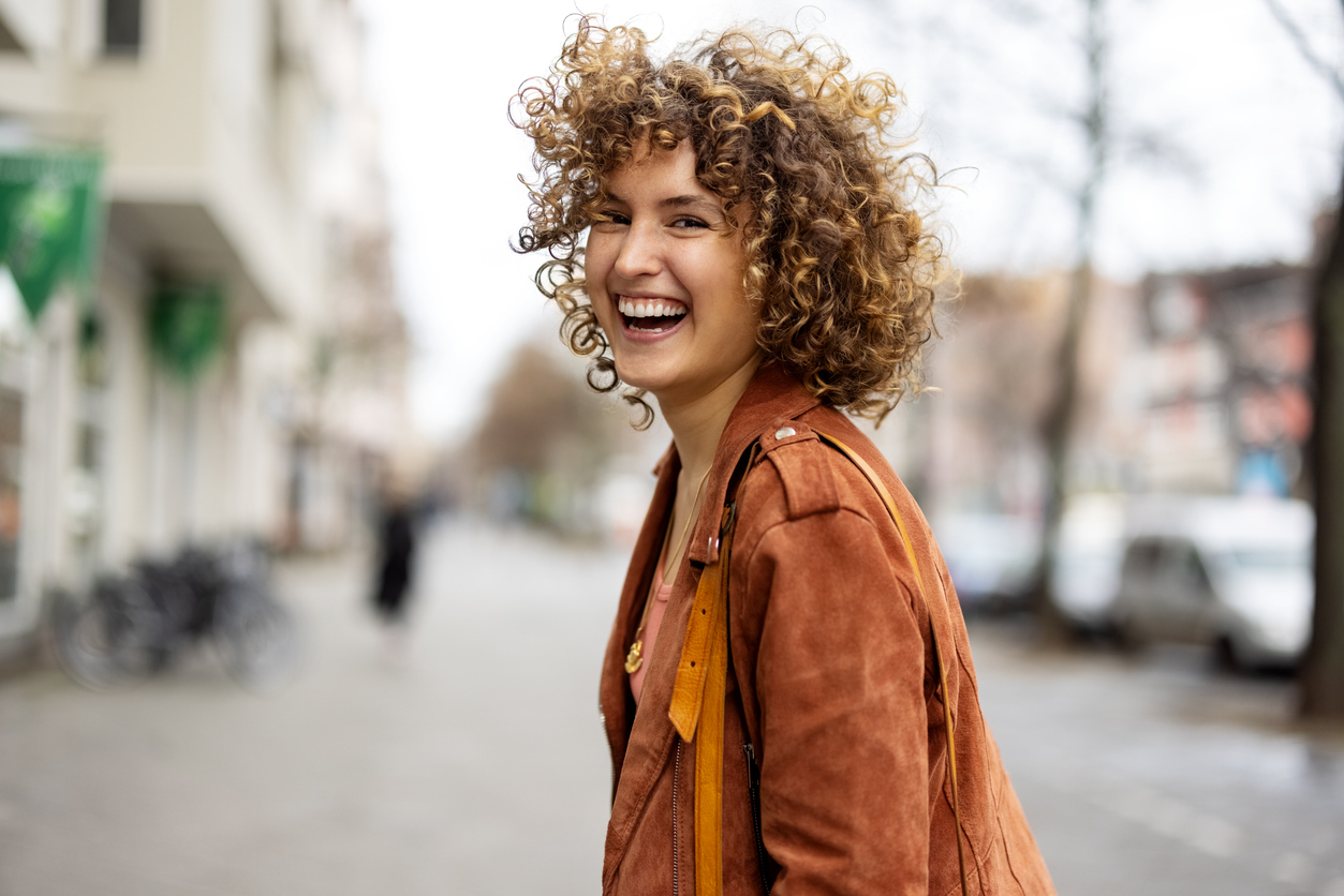Cosmetic periodontics: woman smiling joyfully outside