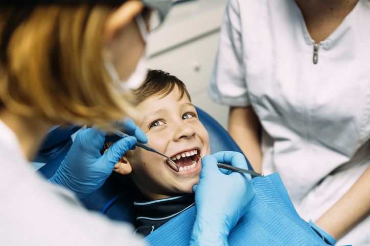 Young male child in dental chair smiling